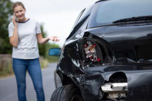 Woman next to vehicle calling lawyer after car accident