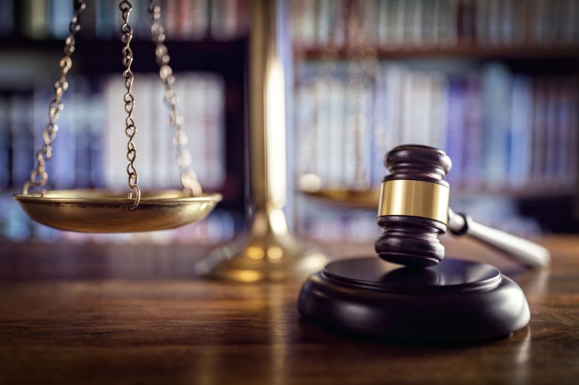 scales of justice and gavel on a desk in a law office