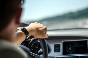 Man driving with his hand on the wheel